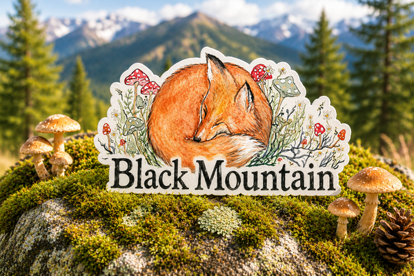 Watercolor sleeping fox sticker with mushrooms and wildflowers reading Black Mountain